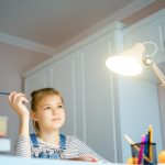 Portret szczęśliwego chłopca z zapaloną lampą w domu