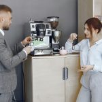 Biznesowy mężczyzna i kobieta w biurze. Przerwa kawowa na korytarzu wielkiej korporacji.