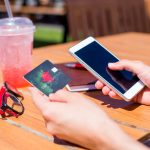 Zamknij się zdjęcie kobiecych rąk za pomocą smartfona i karty kredytowej na zakupy online
