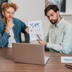 Koledzy z pracy pracujący na laptopie