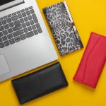 Laptop i wiele stylowych portfeli na żółto.