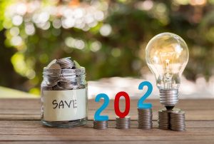 Oszczędność pieniędzy i monet w szklanej butelce na drewnianej podłodze. Koncepcja inwestycji na przyszłość. Z tłem bokeh