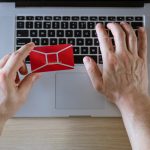 Męskie ręce trzymają kartę kredytową z laptopem, koncepcja zakupów online w sklepie internetowym