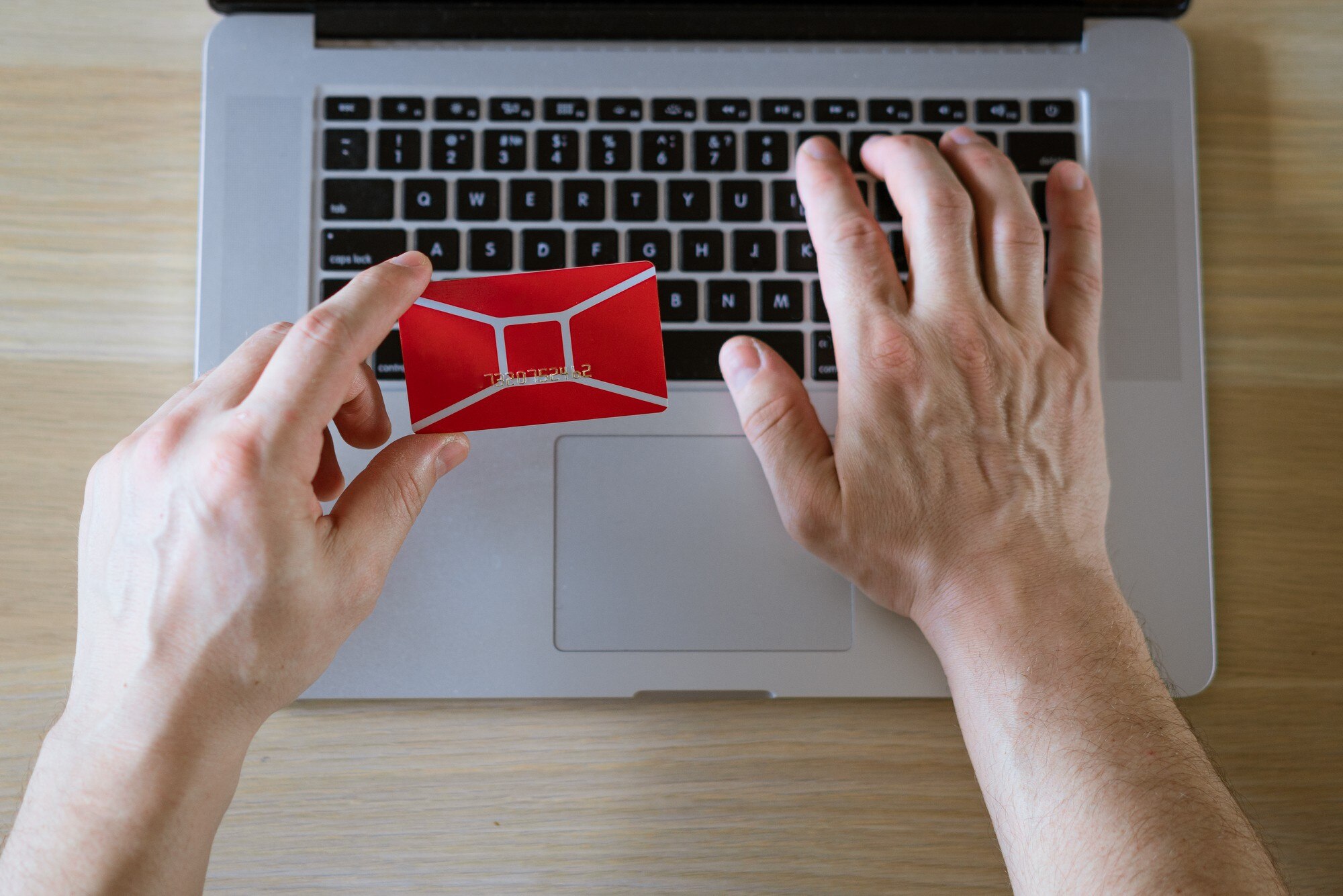 Męskie ręce trzymają kartę kredytową z laptopem, koncepcja zakupów online w sklepie internetowym