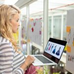 Graficzna projektantka używająca laptopa w studiu projektowym