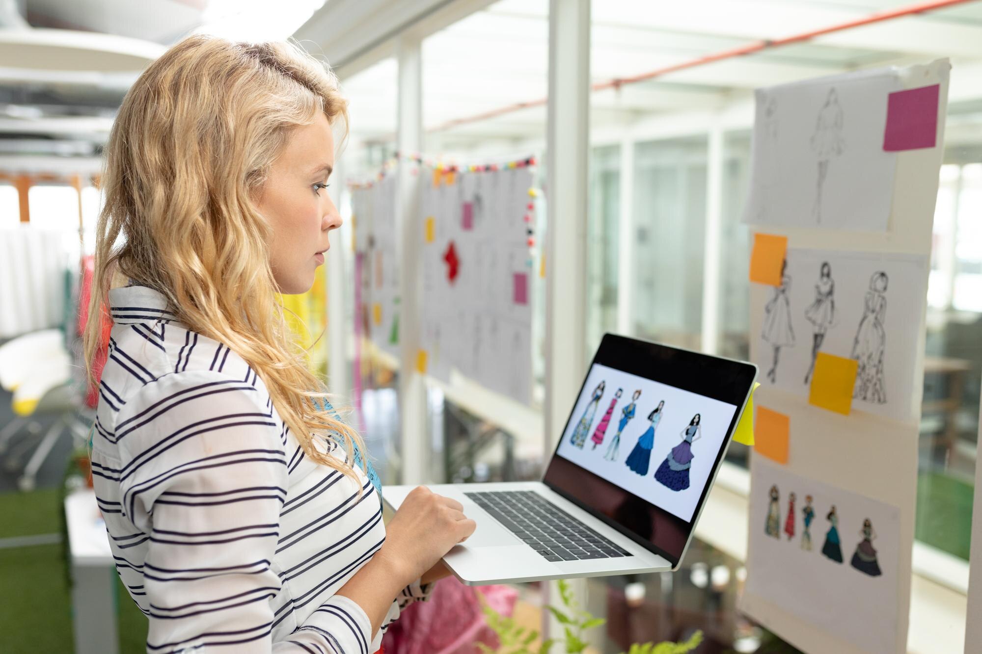 Graficzna projektantka używająca laptopa w studiu projektowym