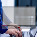 Mężczyźni stojący i piszący o filmie, korzystając z notebooka na białym stole