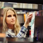 Dziewczyna zbieranie książek w bibliotece