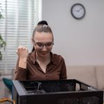 Pracownik biurowy próbuje naprawić uszkodzony komputer rozebrany na części