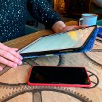 Zbliżenie dziewczyna pracuje lub studiuje w kawiarni z tabletem, telefonem i notebookiem są w pobliżu. Coworking, organizacja pracy. Koncepcja biznesu lub edukacji.