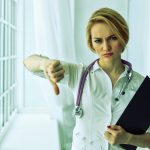 Zbliżenie portret, kobieta lekarz, dając kciuk w dół gest patrząc z negatywnej wypowiedzi, dezaprobata. stonowane.