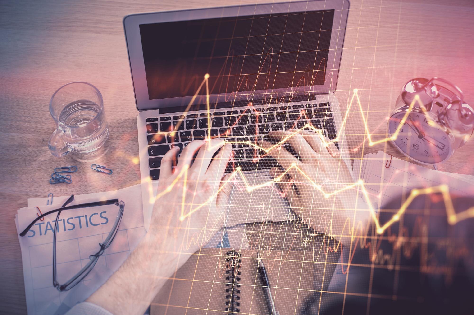 Podwójna ekspozycja rąk człowieka piszącego na klawiaturze laptopa i rysowanie hologramu wykresu forex Top view Koncepcja rynków finansowych