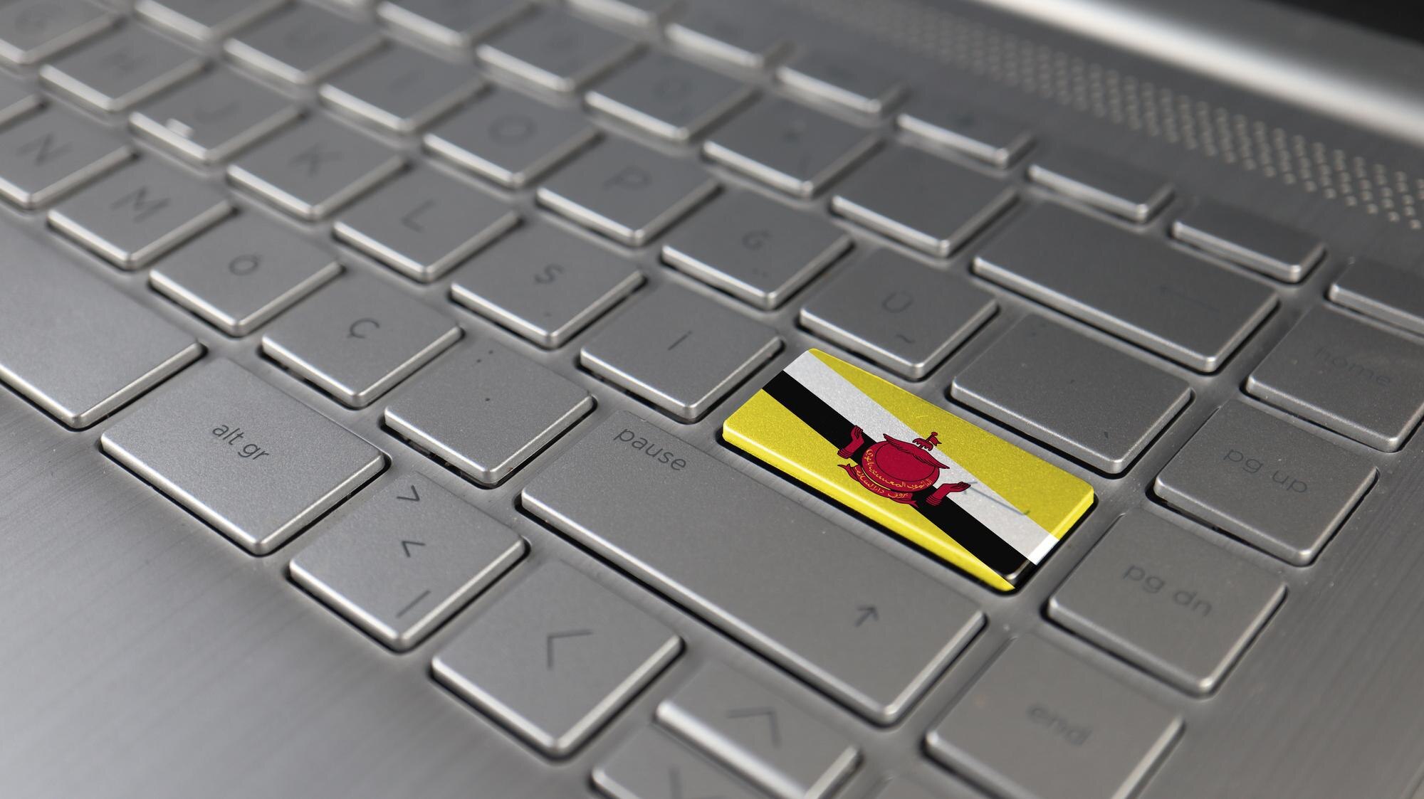 Klawiatura z flagą Brunei na przycisku enter reprezentuje język uczenia się cyberataku