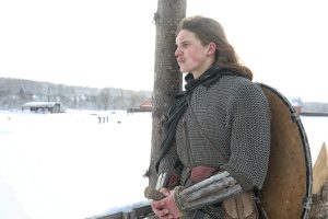 Broń młodego wojownika w zbroi kolczugowej uzbrojonego w miecz i topór