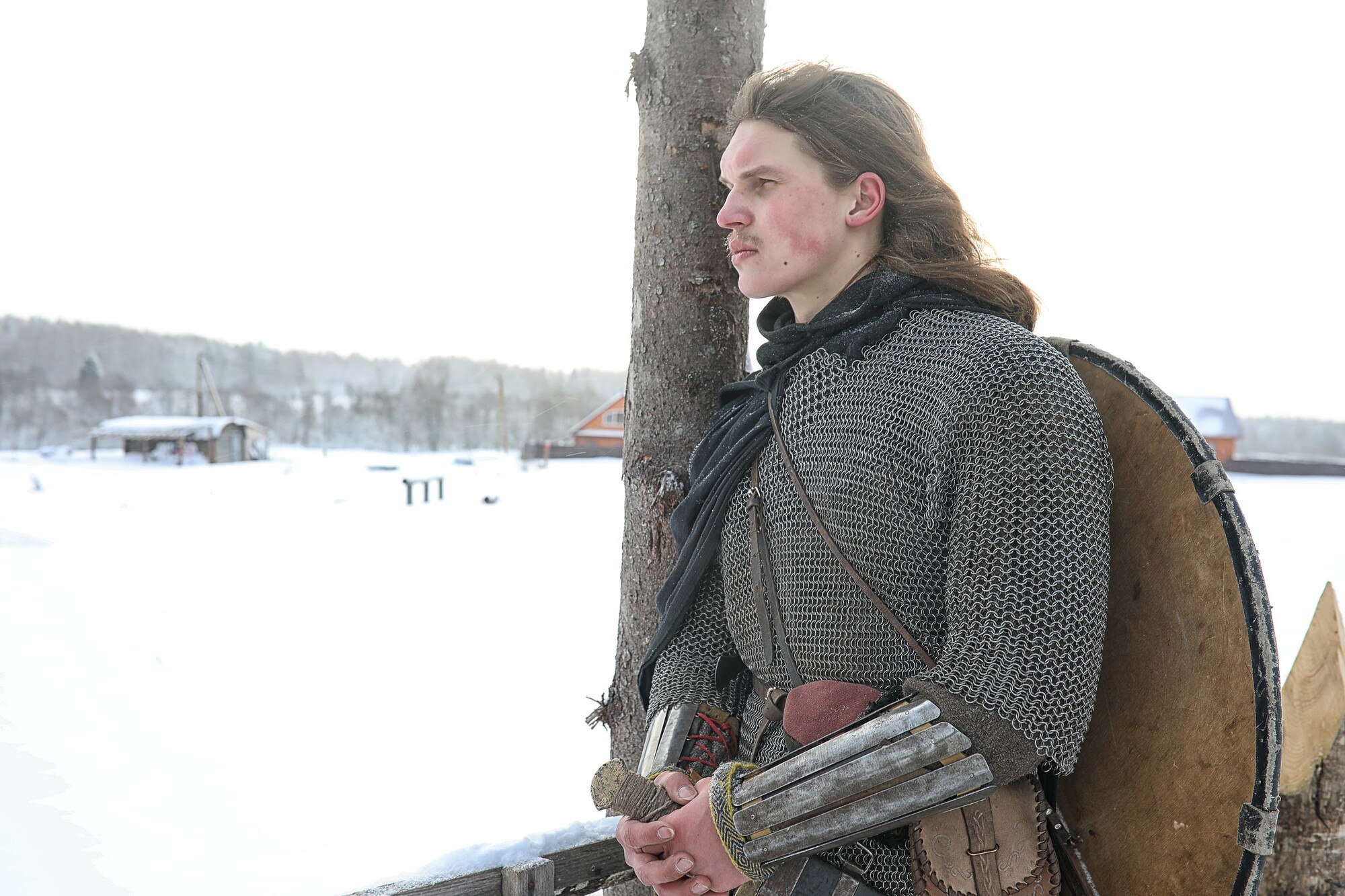 Broń młodego wojownika w zbroi kolczugowej uzbrojonego w miecz i topór