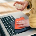 Ścieśniać. młoda kobieta, traktując swojego laptopa przed bakteriami wirusowymi. zdjęcie z kopią przestrzeni