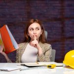 widok z przodu inżynierka siedząca za swoim miejscem pracy z dokumentami program budowniczy pracy sukces biznesowy plan nieruchomości wykonawca