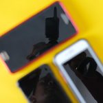 Rozmazane trzy smartfony na żółtym tle