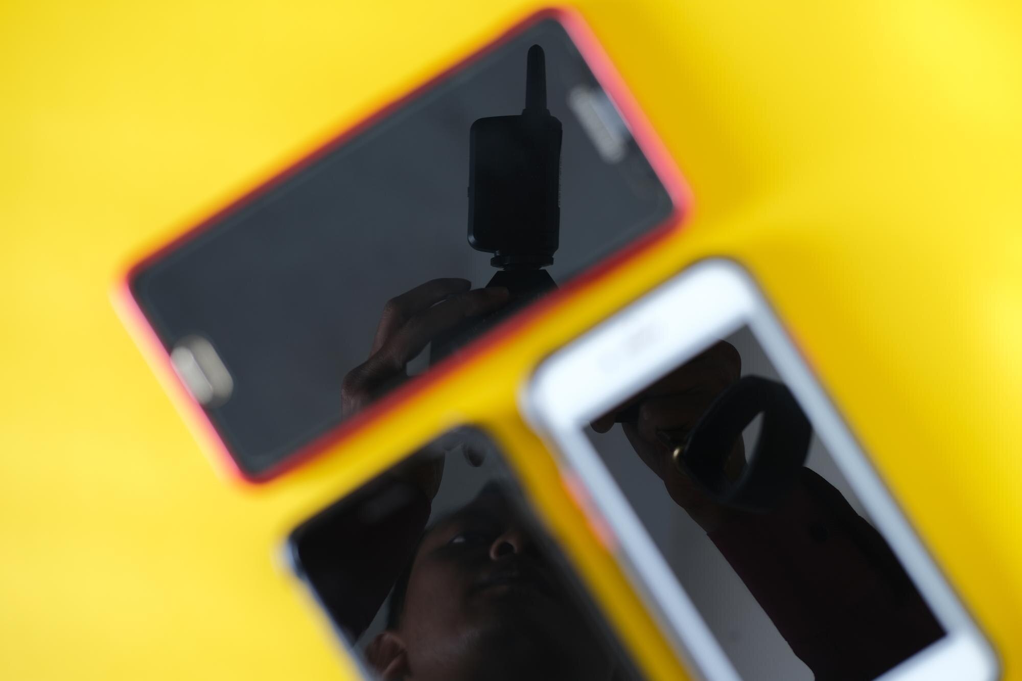 Rozmazane trzy smartfony na żółtym tle