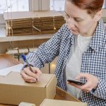 Kobieta biznesu pakuje zamówienia ze swojego sklepu internetowego Mała firma pracuje z domu