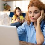 Rodzic próbuje pracować w domu w otoczeniu dzieci