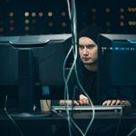 Haker w zestawie słuchawkowym i okularach z hackowaniem systemu komputerowego lub programowaniem klawiatury