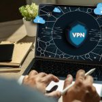 Sieć zabezpieczeń VPN z człowiekiem korzystającym z sieci prywatnej ochrony laptopa