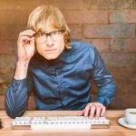 Złożony obraz skoncentrowanego hipsterskiego biznesmena korzystającego z komputera