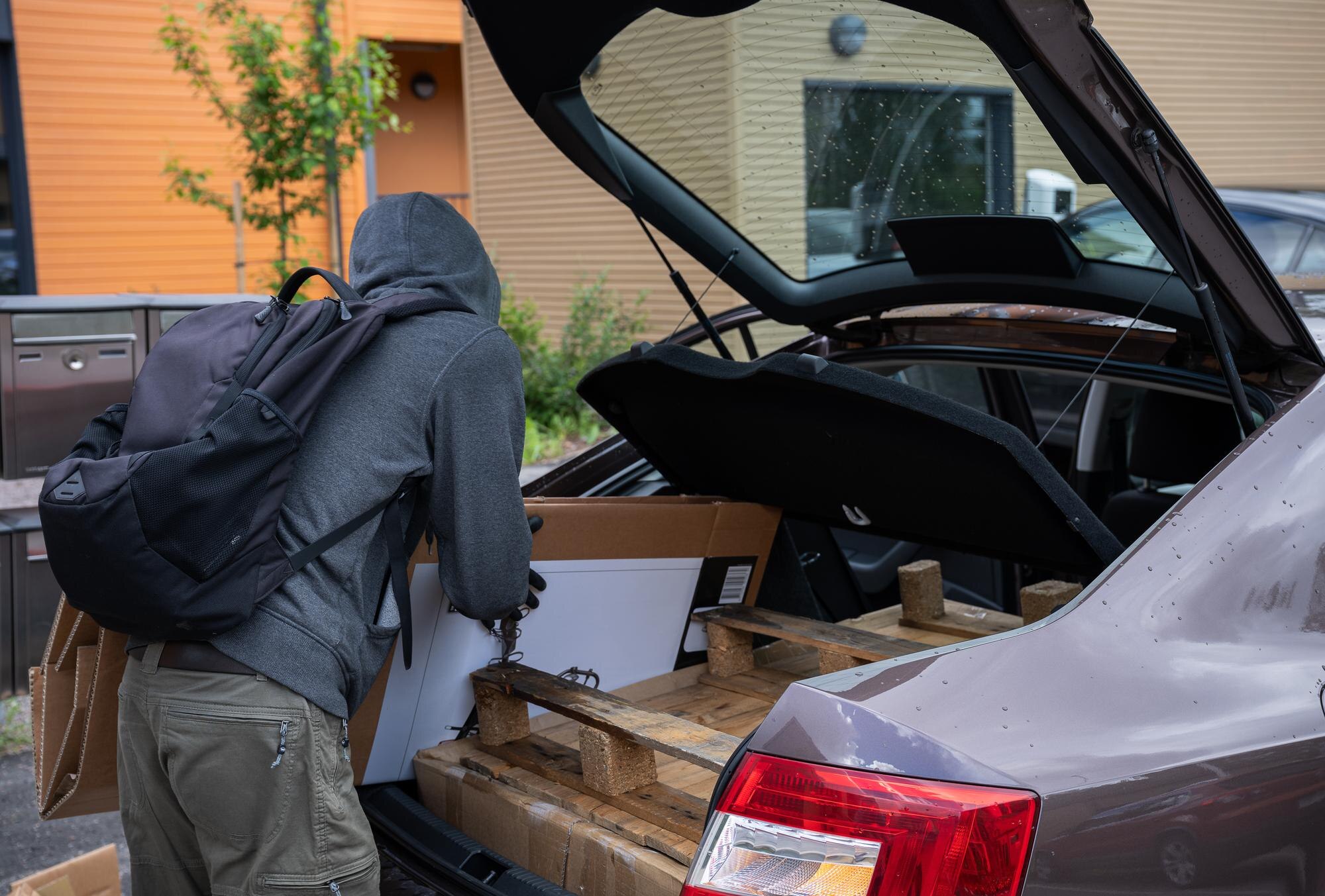 Mężczyzna załadowujący pudełka do bagażnika samochodu