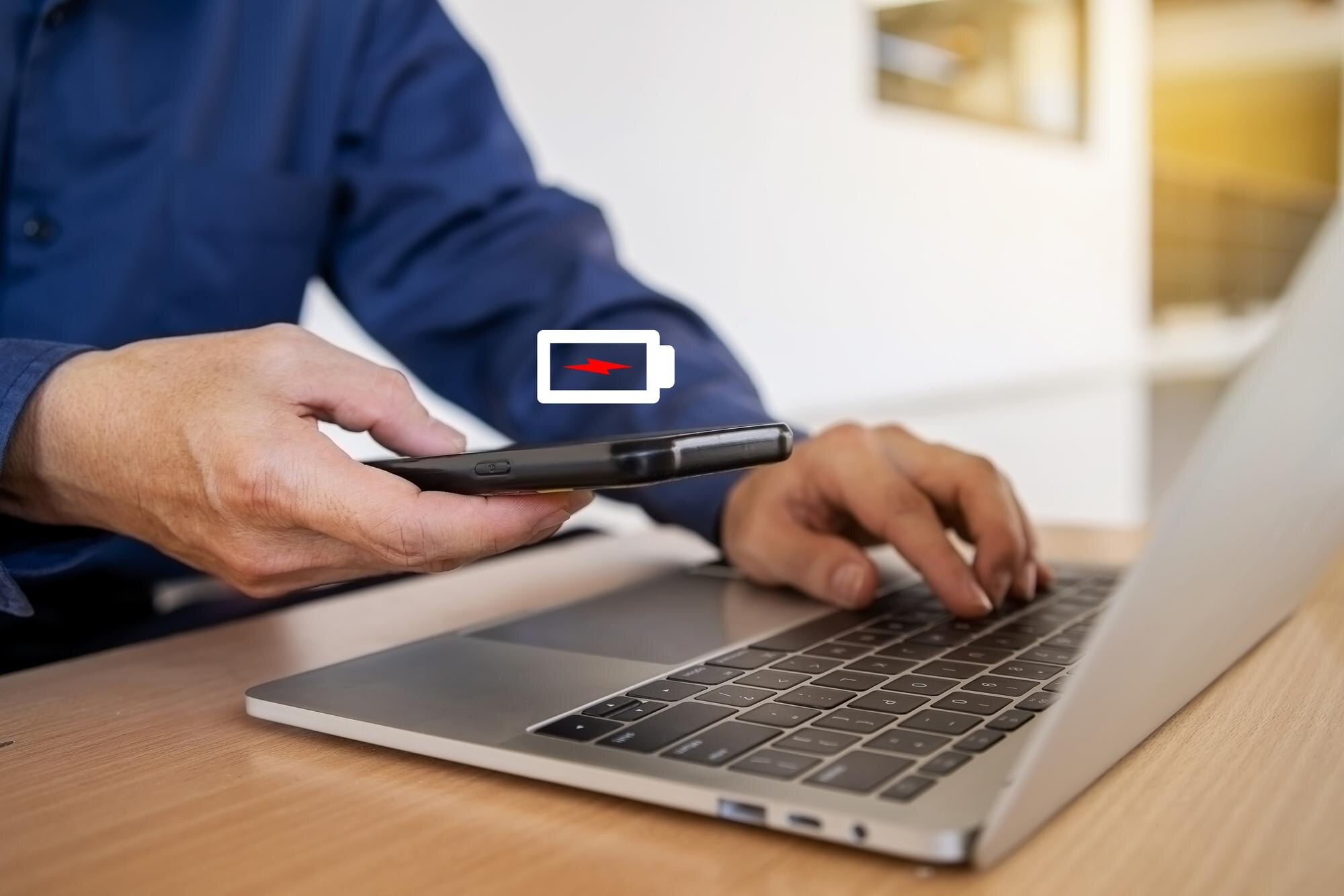 Biznesmen trzymający telefon z ekranem niskiego poziomu naładowania baterii