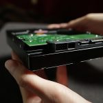 Dysk twardy z bliska zbiory Kobiece dłonie pokazujące spód dysku hdd