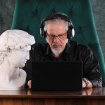 mężczyzna siedzący z laptopem w nocy