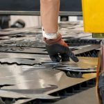 Wycinarka laserowa tnie arkusze drewna, podczas gdy mężczyzna zajmuje się procesem ameryka łacińska