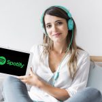 Młoda kobieta trzymająca tablet z aplikacją Spotify