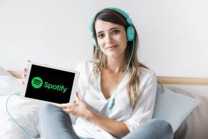 Młoda kobieta trzymająca tablet z aplikacją Spotify