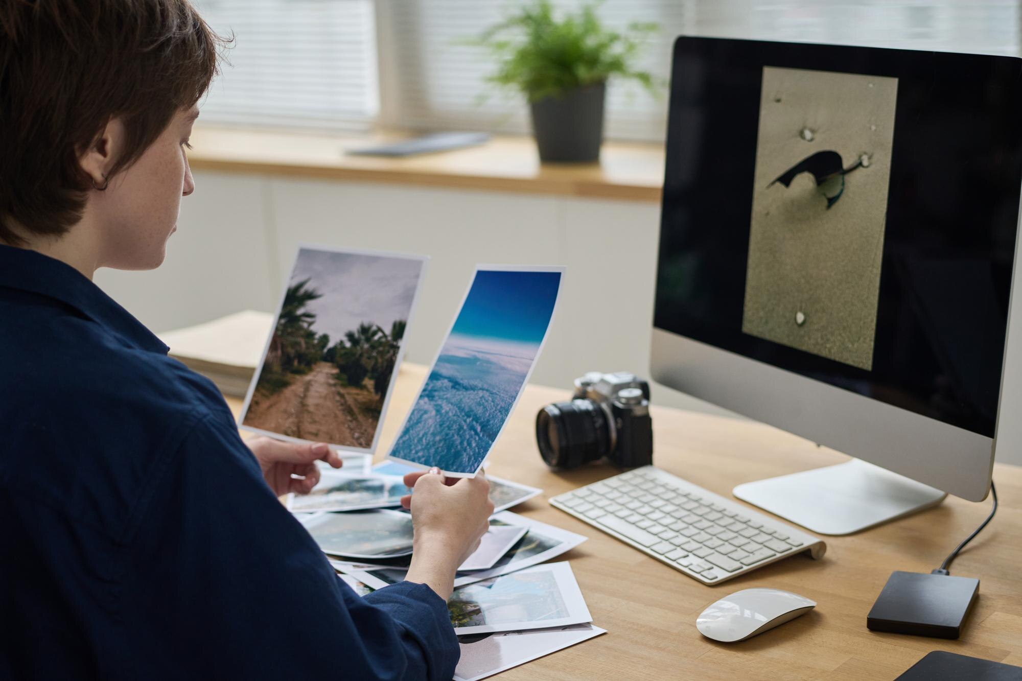 Fotograf bada zdjęcia w swoim miejscu pracy