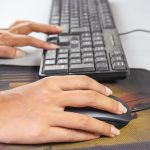 osoba używająca myszy komputerowej z literami q na klawiaturze