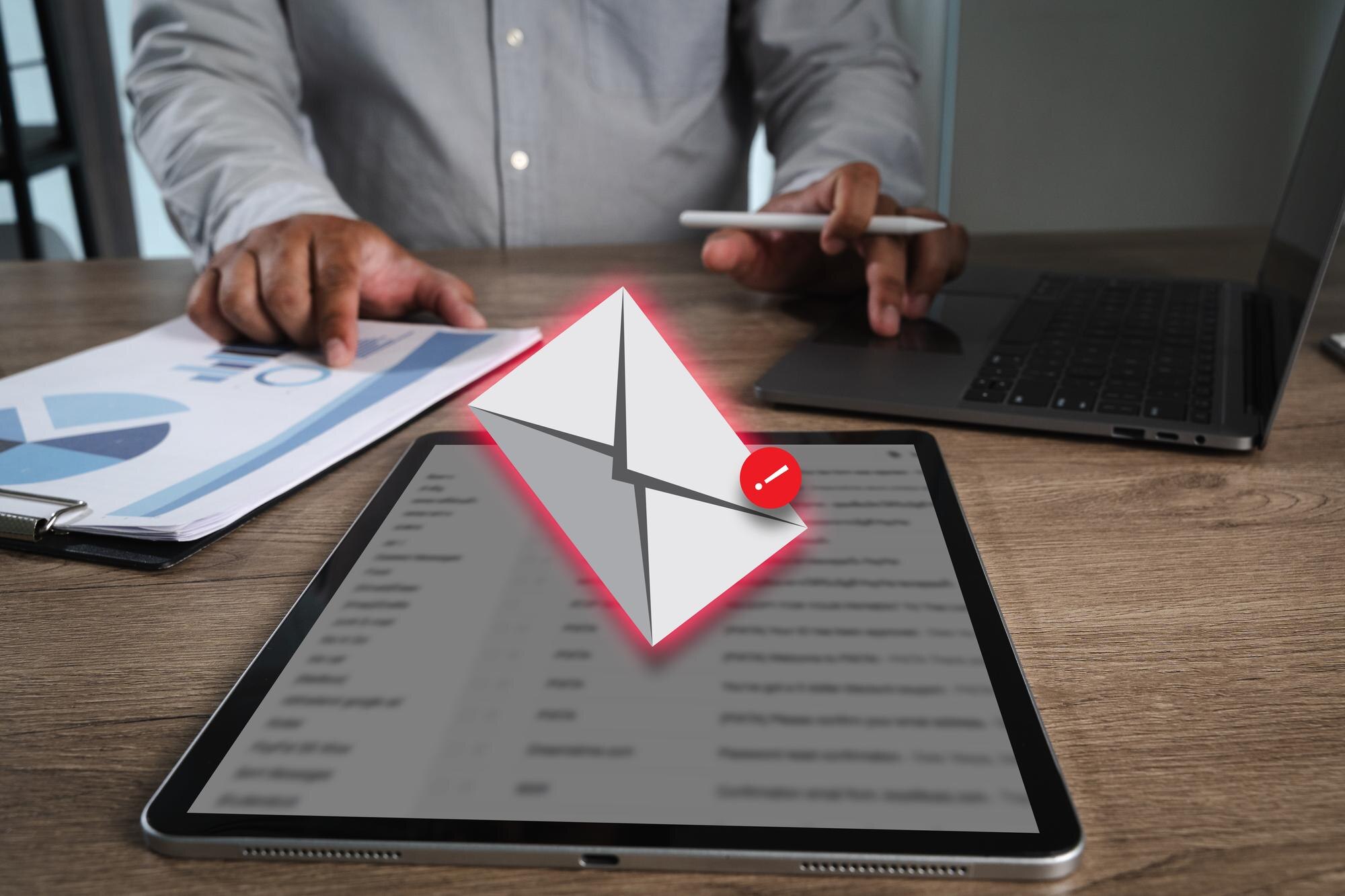 Phishing mail person working desk with tablet displaying email notification laptop and documents with charts indicating business or office