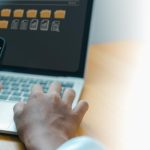 Businessman using smartphone and laptop for digital document management system
