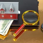 Znalezienie i zakup domu przez Internet Model domu na tle laptopa i lupy