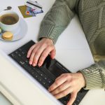 Ręce używają kart kredytowych laptopa leżących w pobliżu bizneswoman lub przedsiębiorcy pracującego w domu