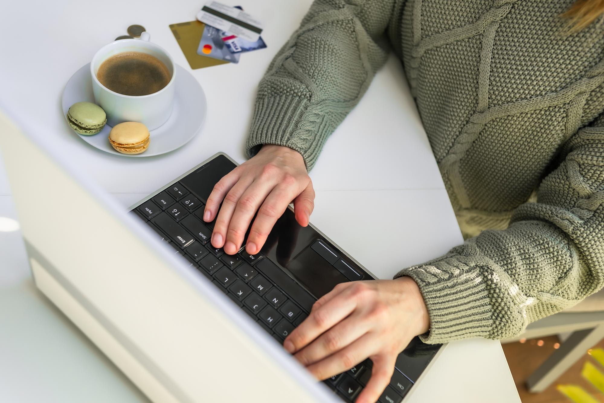 Ręce używają kart kredytowych laptopa leżących w pobliżu bizneswoman lub przedsiębiorcy pracującego w domu