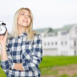 Młoda kobieta, wskazując na zegar