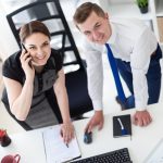 Młodzi ludzie w biurze, patrząc na monitor.