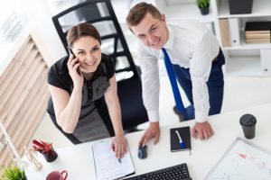 Młodzi ludzie w biurze, patrząc na monitor.