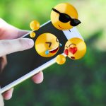 Kobieta używa smartphone wysyła emoji.