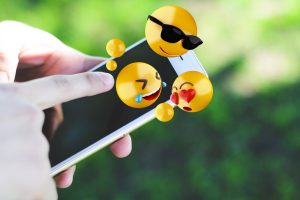 Kobieta używa smartphone wysyła emoji.