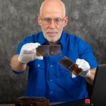 Technik w białych rękawiczkach digitalizuje starą fotografię na szklanym talerzu