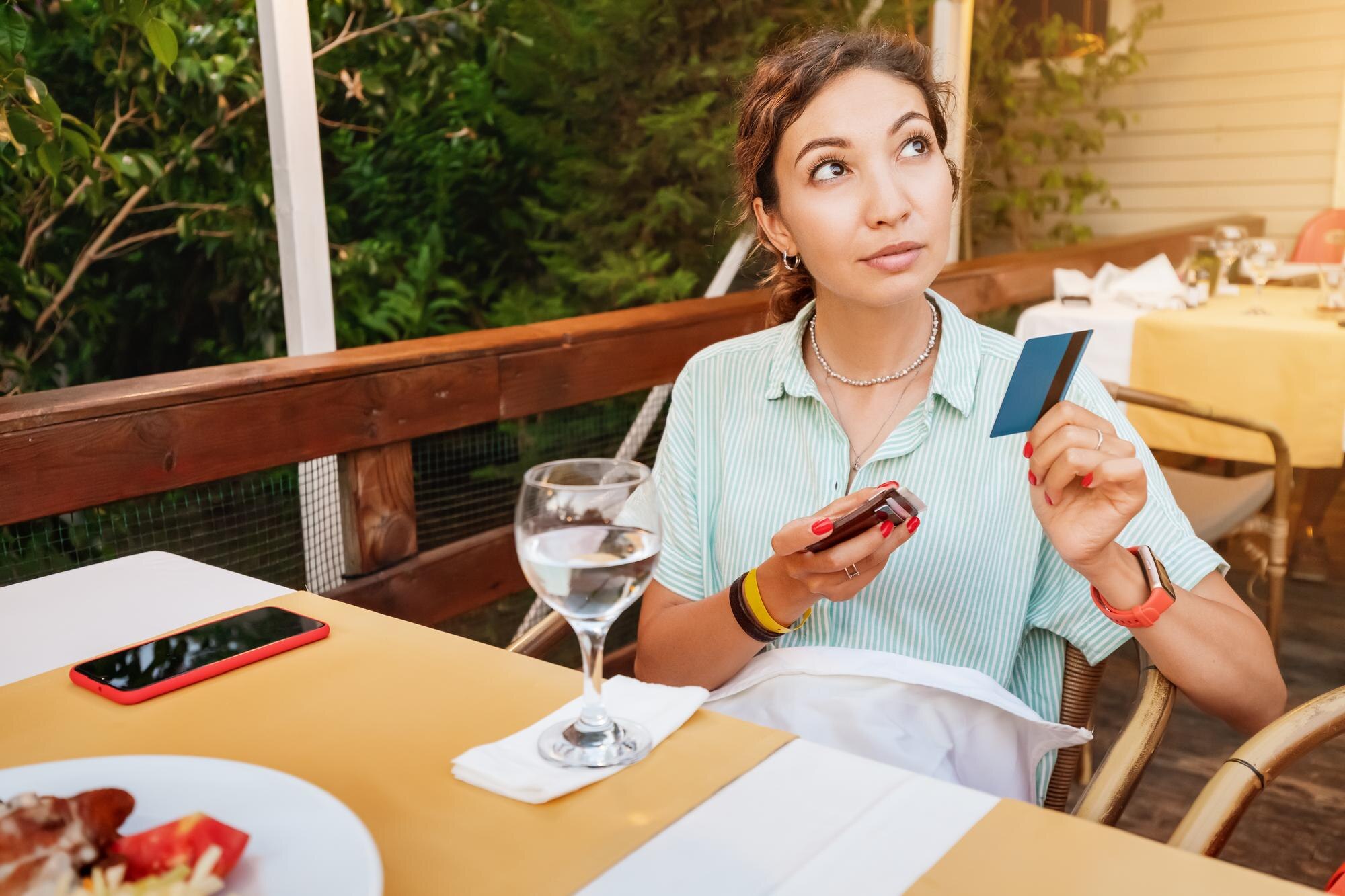 Kobieta płaci kartą kredytową po kolacji w kawiarni Nowoczesne technologie transakcyjne i banki