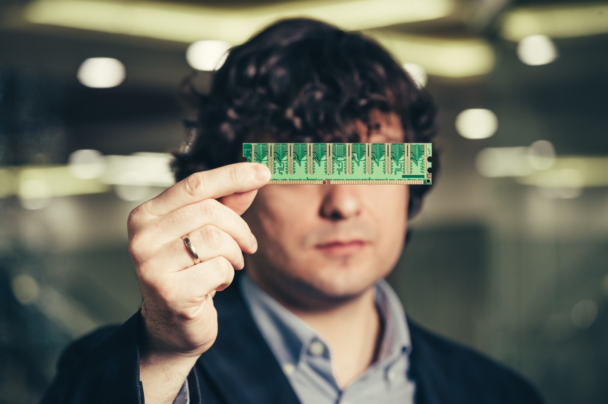 poważny człowiek zamknął oczy mikroukładem. RAM w rękach biznesmena. Anonimowy chowający się za chipem. Pamięć o dostępie losowym.
